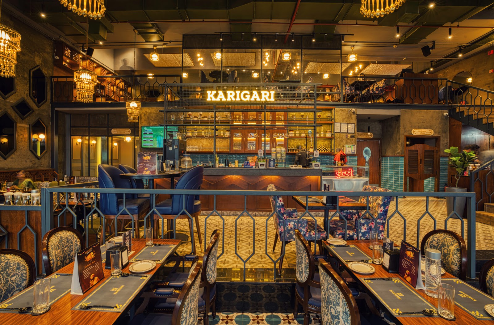 Karigari's dining room in Sector 51: set tables, patterned chairs and the lit bar behind them
